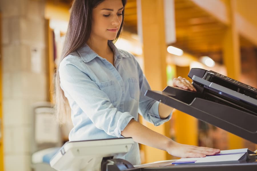 smiling brunette using a commercial printer