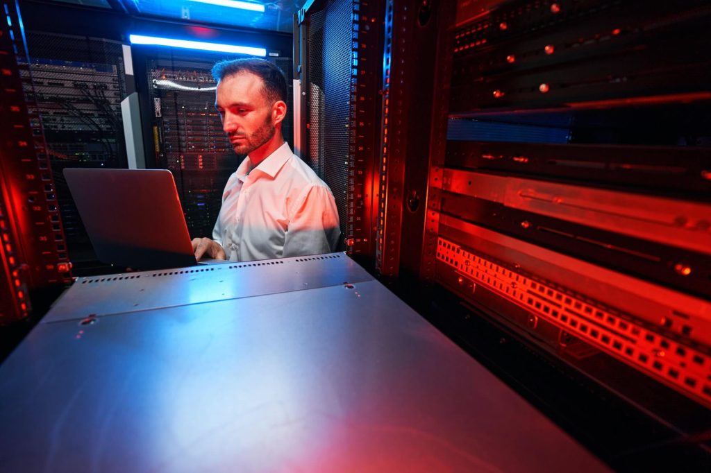 Guide to Colocation and How to Choose a Provider 11 data center administrator inspecting server rack software 1