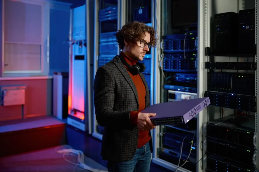 a man holding a large object in front of a server room
