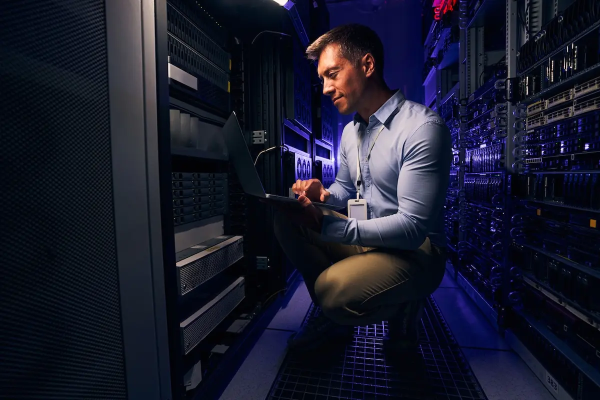 a man squatting down in a server room